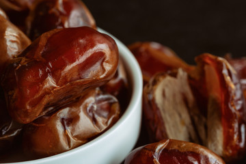 Khalas date palm on black granite table in close up with copy space for background or wallpaper. Dates fruit is food for Ramadan or medjool. Delicious dried fruit with sweet taste and have high fiber