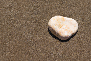 Light cobblestone of marble on a sandy beach, copy space