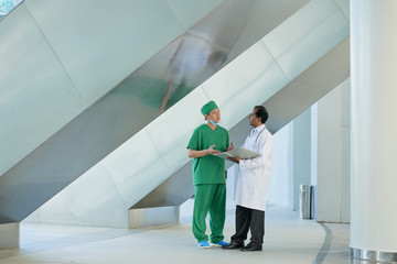 Two doctors standing at the hospital and discussing work