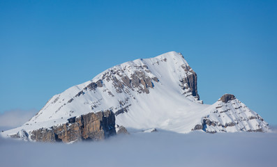 The top of a mountain (Grand Veymont) above the winter mist and clouds. Vercors, France.