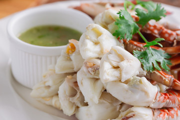 Steamed crab meat prepared for ready to eat with Thai style hot and spicy dipping sauce on white...