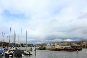 Fototapeta premium Geneva, Switzerland - March 30,2018: Street view on famous lake and yachts on rainy day
