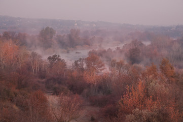 Early misty morning on the river. A winding river among the autumn trees.
