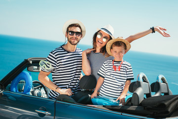 Happy family travel by car to the sea. People having fun in cabriolet. Summer vacation concept