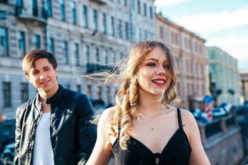 Happy couple is spending vacation holidays in St. Petersburg. Both look really happy. They are strolling along the streets of the old town
