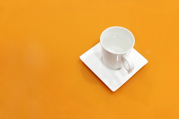 coffee cup white on top table orange, water mug white on background orange