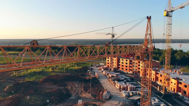 High construstion cranes on a construction site. 4K Aerial shot