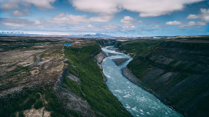 aerial view of river flowing trough cliffs in iceland