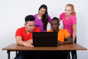 Fototapeta premium Studio shot of diverse group of multi ethnic friends using lapto