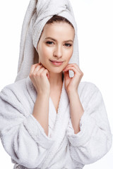 Obraz premium Young woman in a bathrobe and towel on her head, spa and care portrait, clean natural face, portrait on a white background isolated