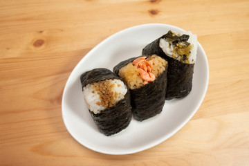 Various types of traditional Japanese rice balls, called Onigiri, wrapped with seaweed.
