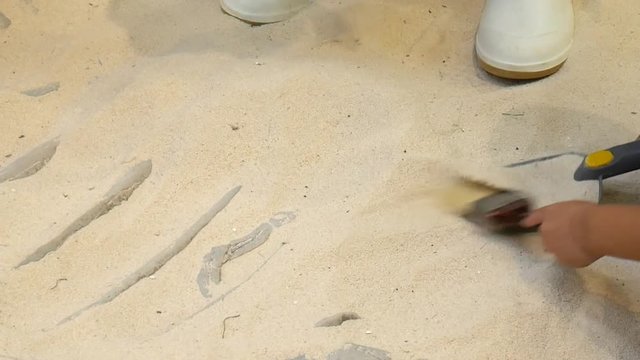 Video of Children play digging for fossil dinosaur bone. It is gently excavated.