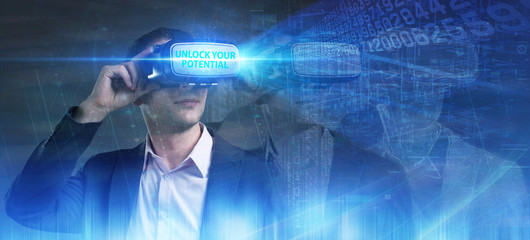 Business, Technology, Internet and network concept. Young businessman working in virtual reality glasses sees the inscription: Unlock your potential