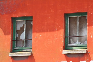 des fenetres de bois vert brisées pour rénovation,vendaliser sur façade orange