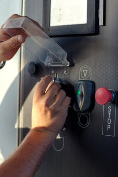 man hand holding a coin money in a car vashing machine to vash the car.