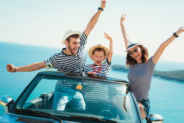 Obraz premium Happy family travel by car to the sea. People having fun in cabriolet. Summer vacation concept