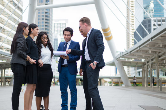 business people standing in the city and discussing ideas for business future. multi culture of business people, African, Caucasian and Asian.