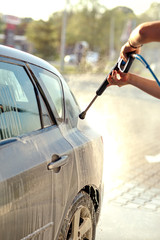 worker wash the car with high pressure washer.