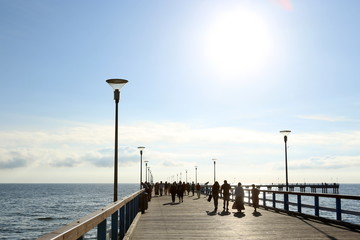 Sea bridge with people at sunset. Pedestrian bridge at the Baltic sea  in Palanga.