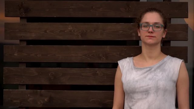 girl in dress showing something with finger against a wooden wall background