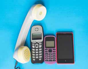 Technology evolution concept, old and new telephones on the blue background.