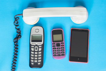Technology evolution concept, old and new telephones on the blue background.