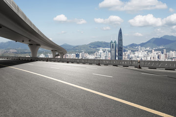 asphalt road with city skyline