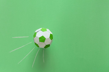 Paper soccer ball on soccer field or green background. Origami. Paper craft. Soccer game concept.