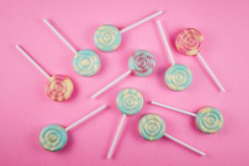Assorment of colorful lollipop on pink background with copy space