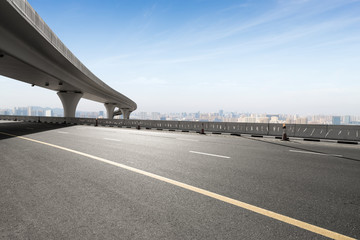 asphalt road with city skyline