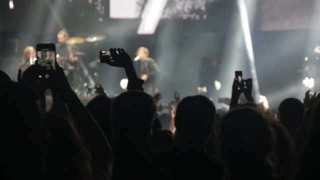 Spectators take a concert on the phone and wave their hands
