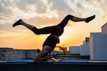 A middle-aged man is engaged in yoga with the use of wheels.