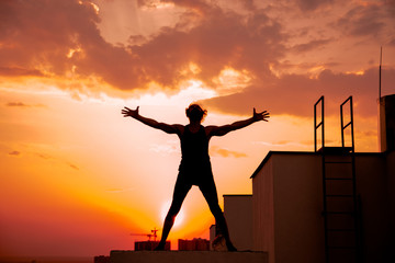 Fototapeta premium A middle-aged man is engaged in yoga on the roof.