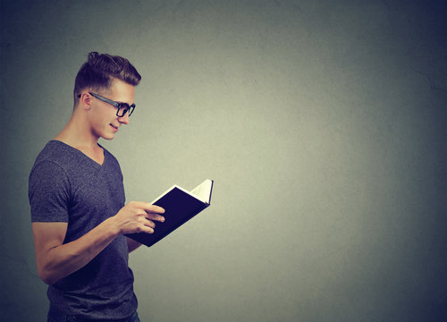 Smart man in glasses reading book