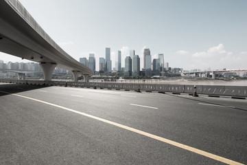 asphalt road with city skyline