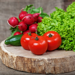 Tomatoes, cucumbers, radishes and lettuce. Vegetables. Square. The concept of healthy eating and vegetarianism.