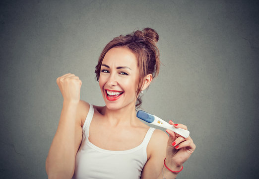 Excited woman with positive pregnancy test