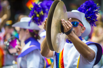 Man in a marching band smashes the symbols together in the annual Pride Parade as it passes through...