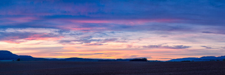 Naklejka na ściany i meble Colorful sunset over plowed fields in Northern Bohemia in the Czech Republic, Europe