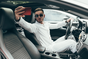 Handsome Young Man Sitting in the Luxury Vehicle