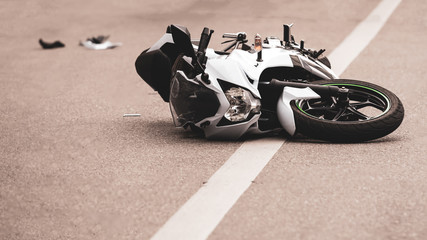 a broken motorcycle lies on the road, an accident, a road, a road, a highway, a road marking,...