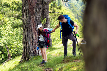 Fototapeta premium Shot of young couple walking through the mountain trail