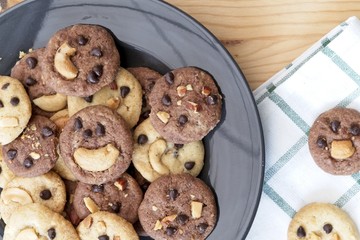 Delicious Chocolate Chip Cookies on black plate, Tasty Homemade cookies on wooden table, dessert with checkered tablecloth. Top view with copy space