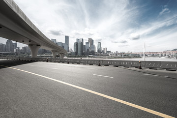 asphalt road with city skyline