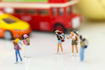 Miniature people: backpacker waiting bus at bus station for go to destination plan. Image use for business travel background concept.