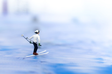 Miniature people, Skier playking ski on snow stream. Image use for sport ,travel concept.