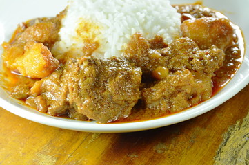 pork curry and potato with rice on plate