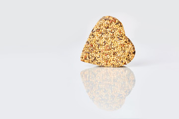 Fodder for birds in a shape of heart on a white background.  Concept of love and care. Horizontal,  space for text
