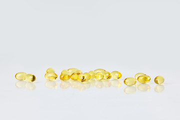Fish oil capsules on white background.  Healthcare concept.  Scattered supplements.  Space for text.  Horizontal