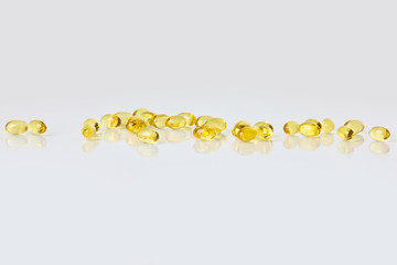 Fish oil capsules on white background.  Healthcare concept.  Scattered supplements.  Space for text.  Horizontal